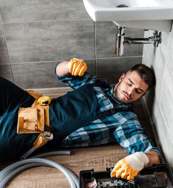 bearded-handyman-lying-on-floor-near-toolbox-in-ba-resize.jpg plumbing services in Dubai